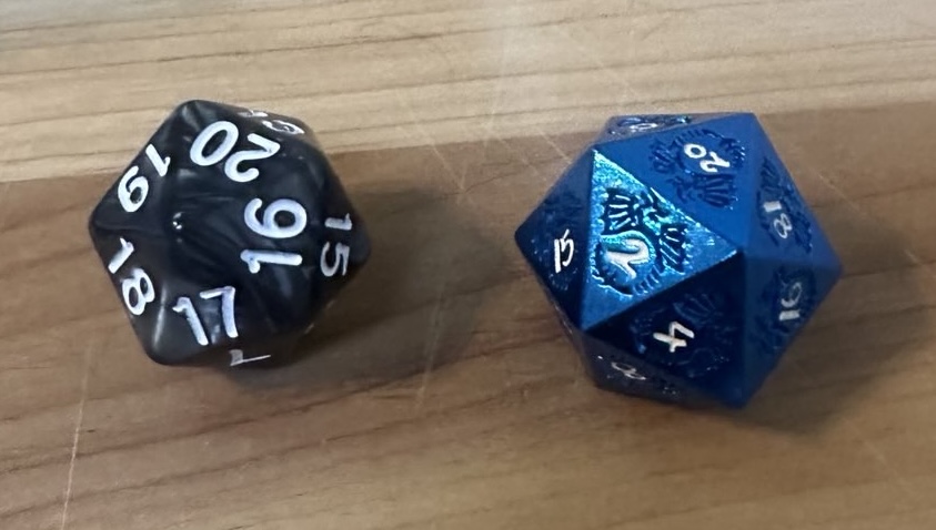 A spindown d20 (left) and a regular d20 (right).